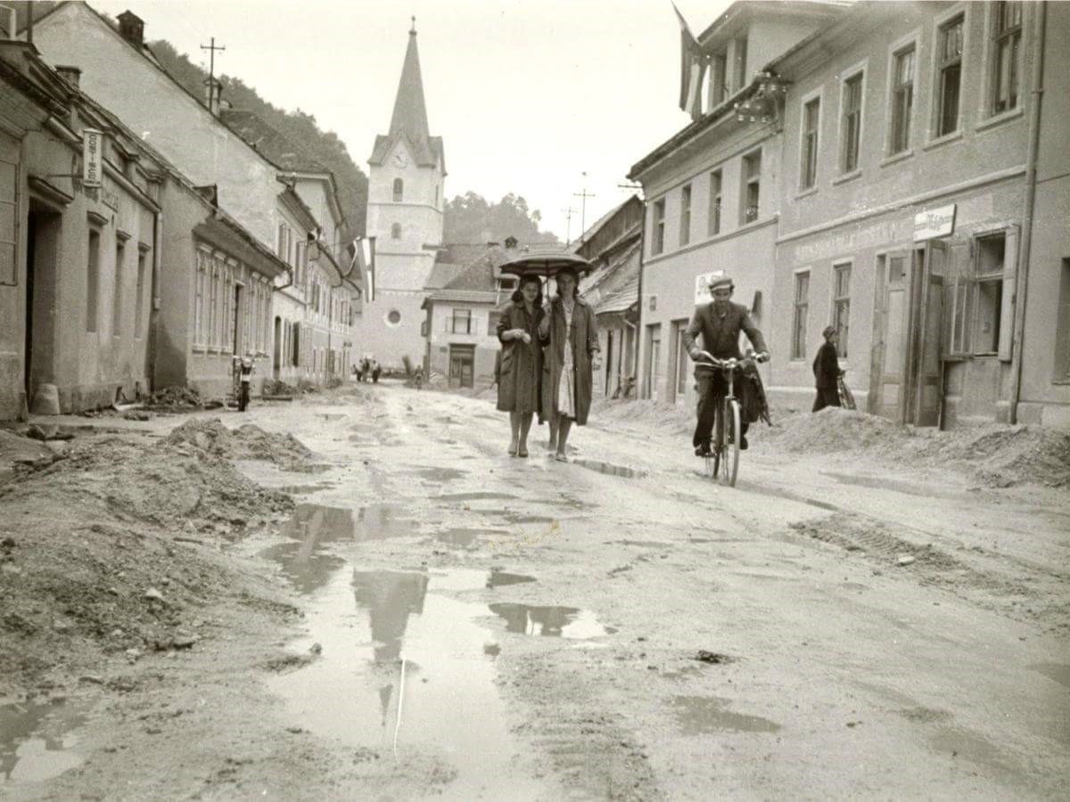 Fotografija očeta muzejskega informatorja Alojza Jelovška na kolesu pred izgradnjo asfaltne ceste v starem mestnem jedru Krškega, okrog leta 1960.