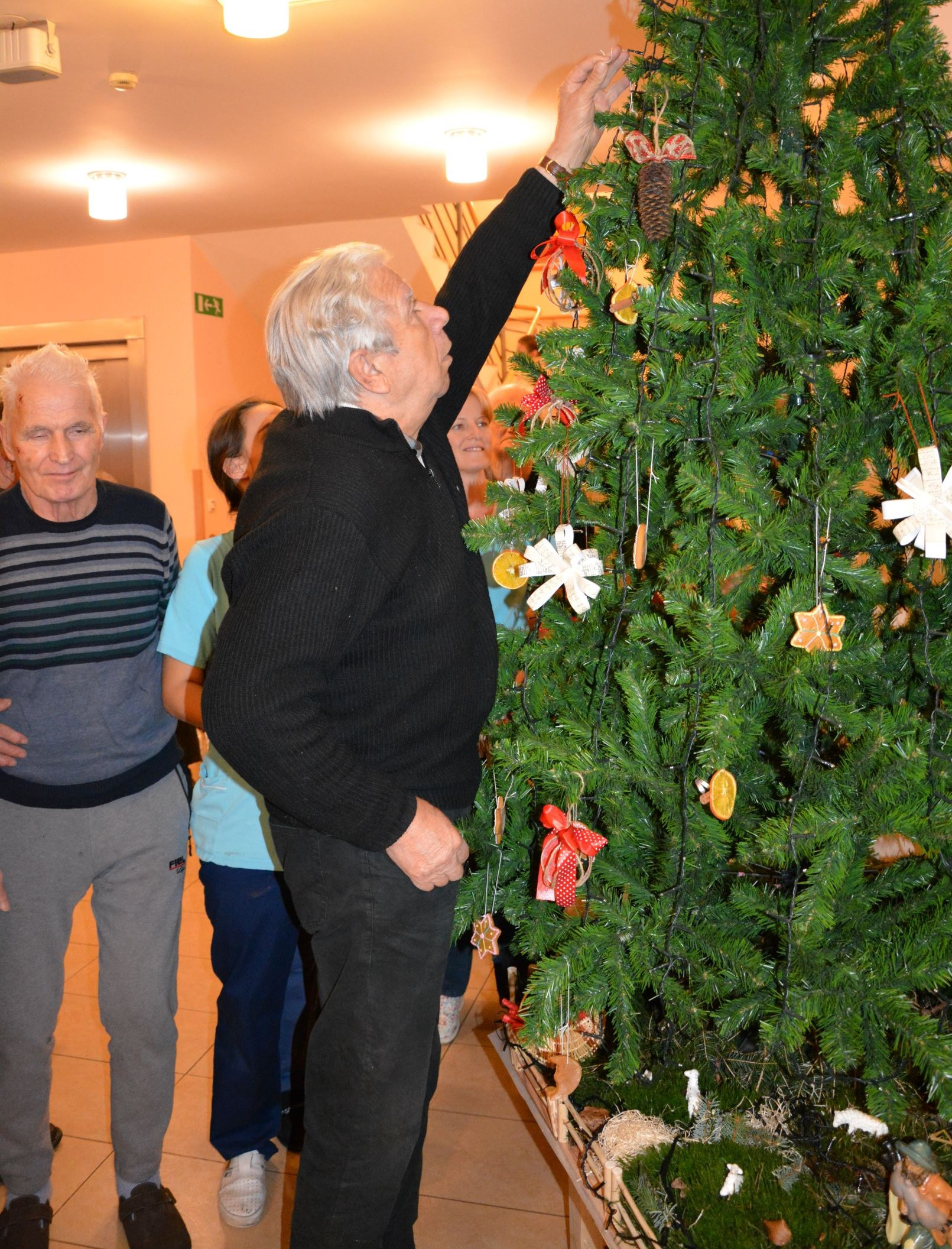 Krasitev smreke in prižig luči ob pesmih zborčka            Sv. Petra pod Sv. Gorami