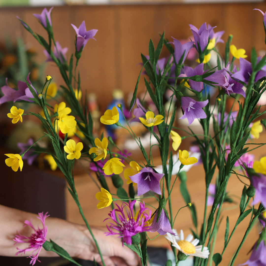 Francka Murn izdeluje rože iz papirja. Foto: Alenka Stražišar Lamovšek, Dolenjski muzej Novo mesto, 2022.